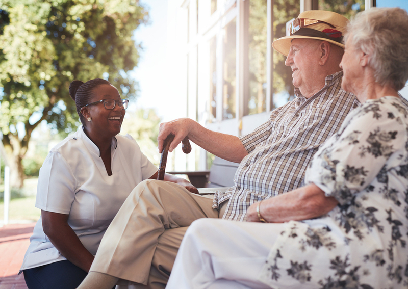 Two seniors talking with a nurse after successfully financing their assisted living.