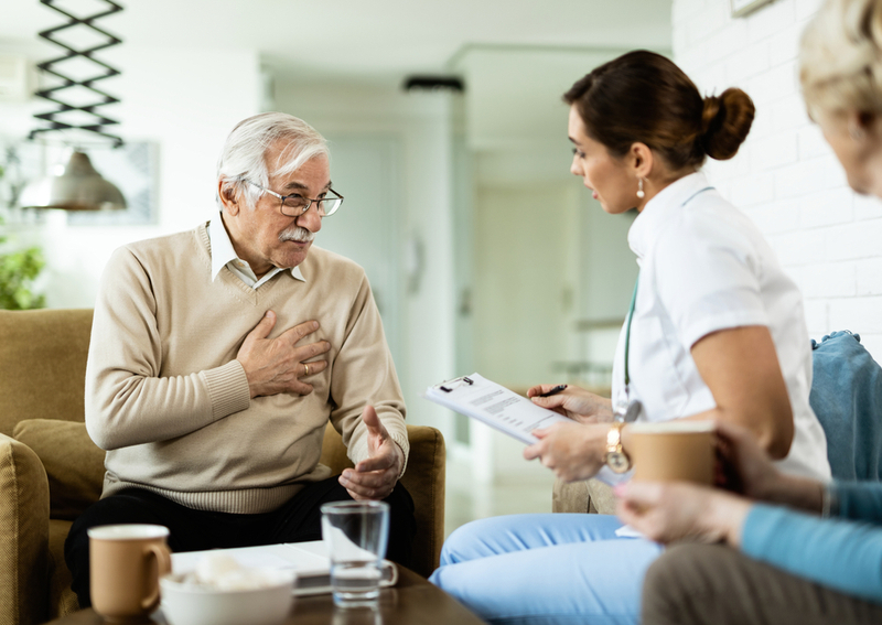 A man and a nurse discussing signs of strokes.