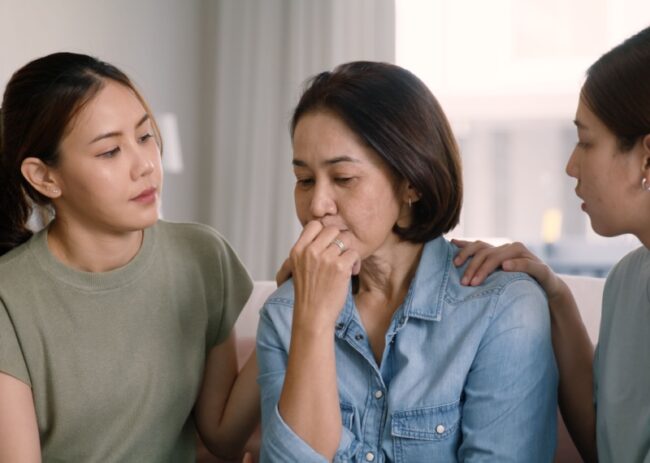 Two daughters speaking to older mother about assisted living