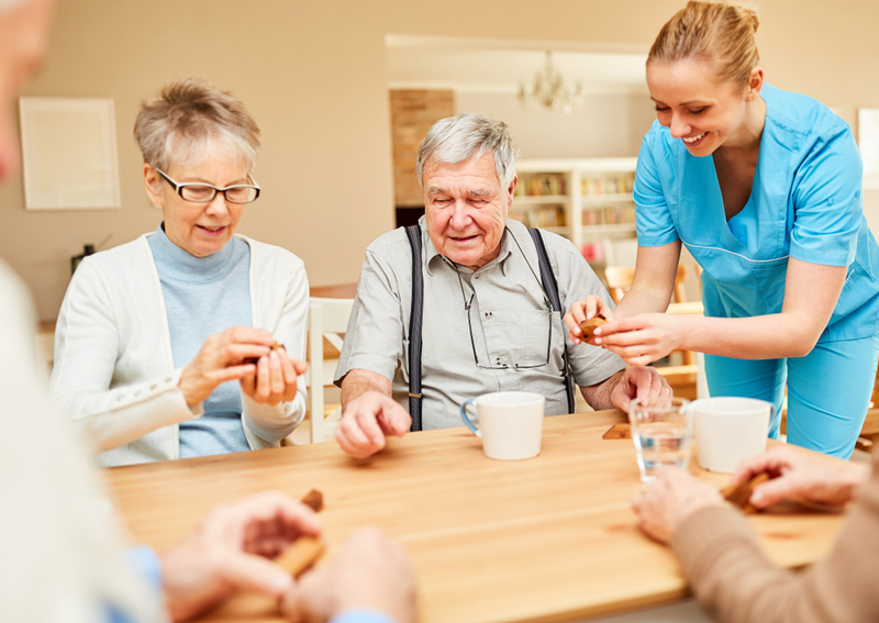 Seniors and a nurse discuss assisted living regulations.