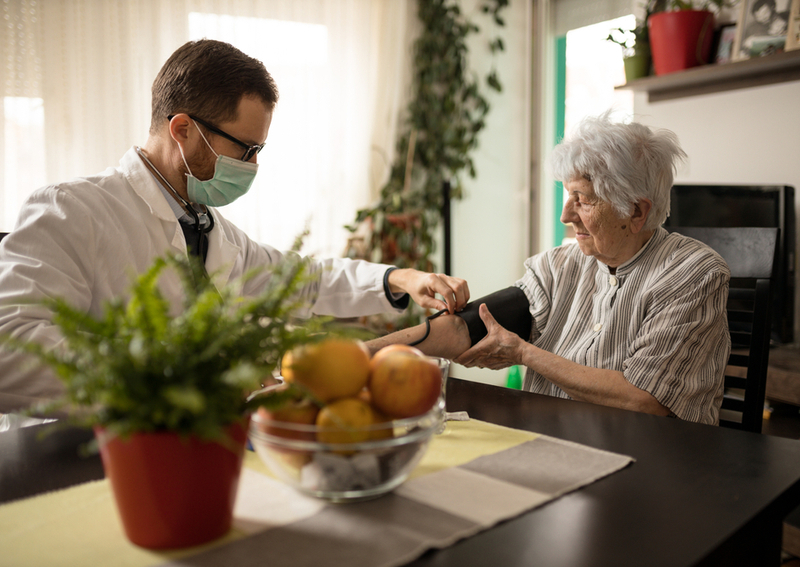 A doctor checks a senior's blood pressure.