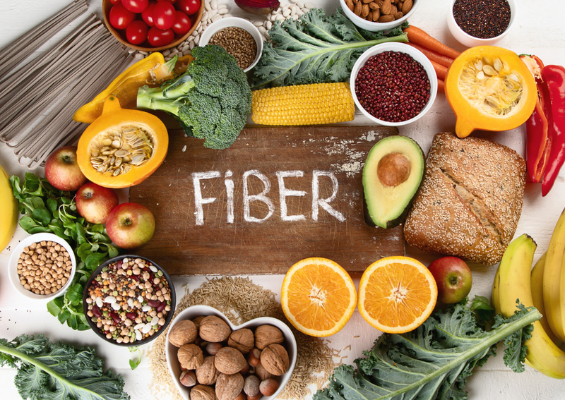 Foods like broccoli, whole wheat pasta, and more that are full of vitamins and fiber are perfect for seniors in assisted living communities. Vegetables and fruit are laid out across a table.