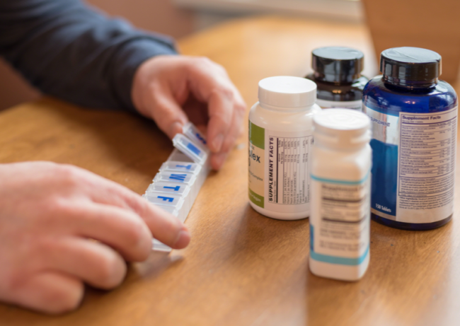 managing-medications-caregiver A caregiver managing medication for a senior.