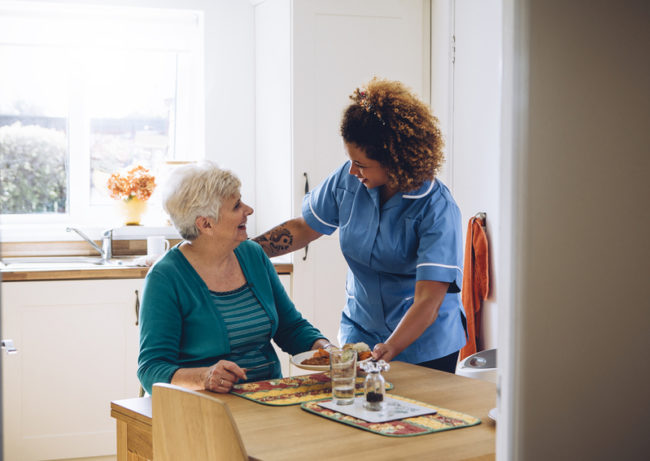 meals-in-assisted-living A senior is given a meal in an assisted living facility.