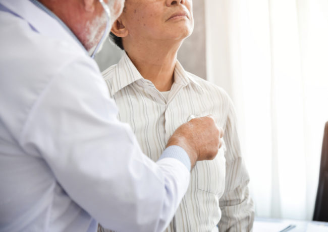 A doctor checks a senior for pneumonia