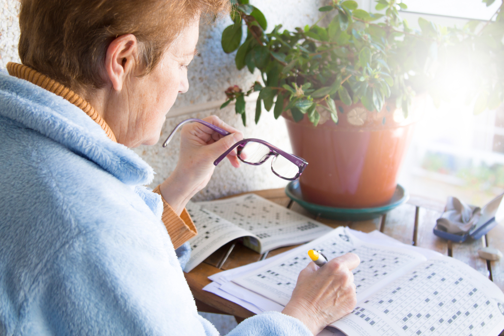 Senior,Woman,Doing,Crossword,Puzzles,Or,Hobbies,Sitting