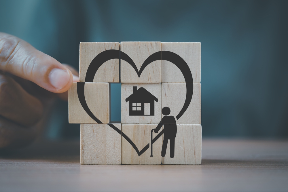 6 wooden blocks stacked with a heart with a home and person with a cane inside