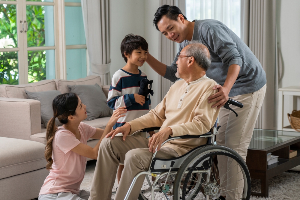 Young Asian Couple And Child Visiting Grandparents In Nursing Home