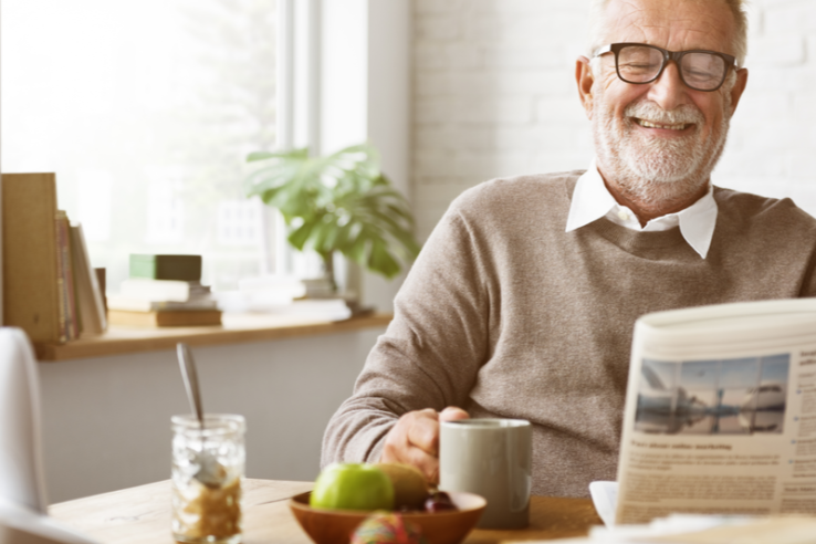 Some-Independent-Senior-Living-Amenities-That-You-Will-Not-Get-At-Home Man happily reading a newspaper and holding cup