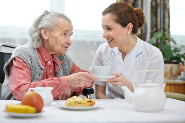 skilled-nursing-home-nutrition-meals A woman in a skilled nursing home being helped by a nurse.